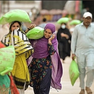 A smiling woman receiving her ration bags